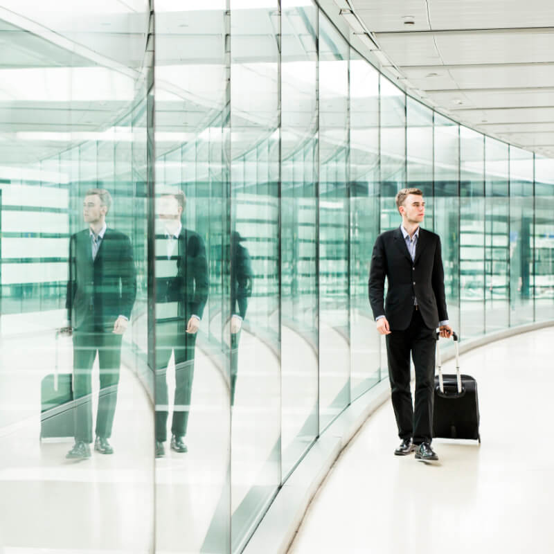 Full length businessman walking with luggage at the airport